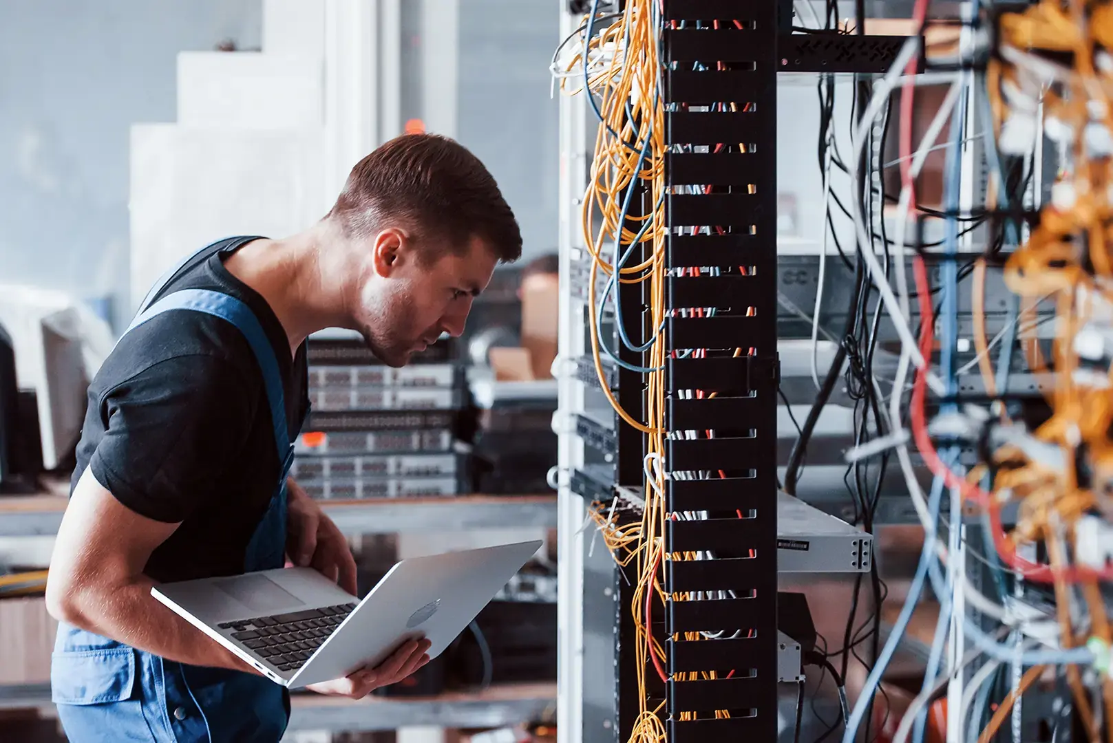 IT technician troubleshooting network cabling in a data center